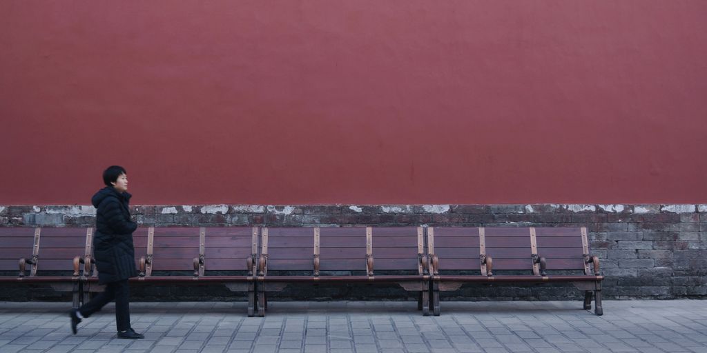 woman walking beside bench